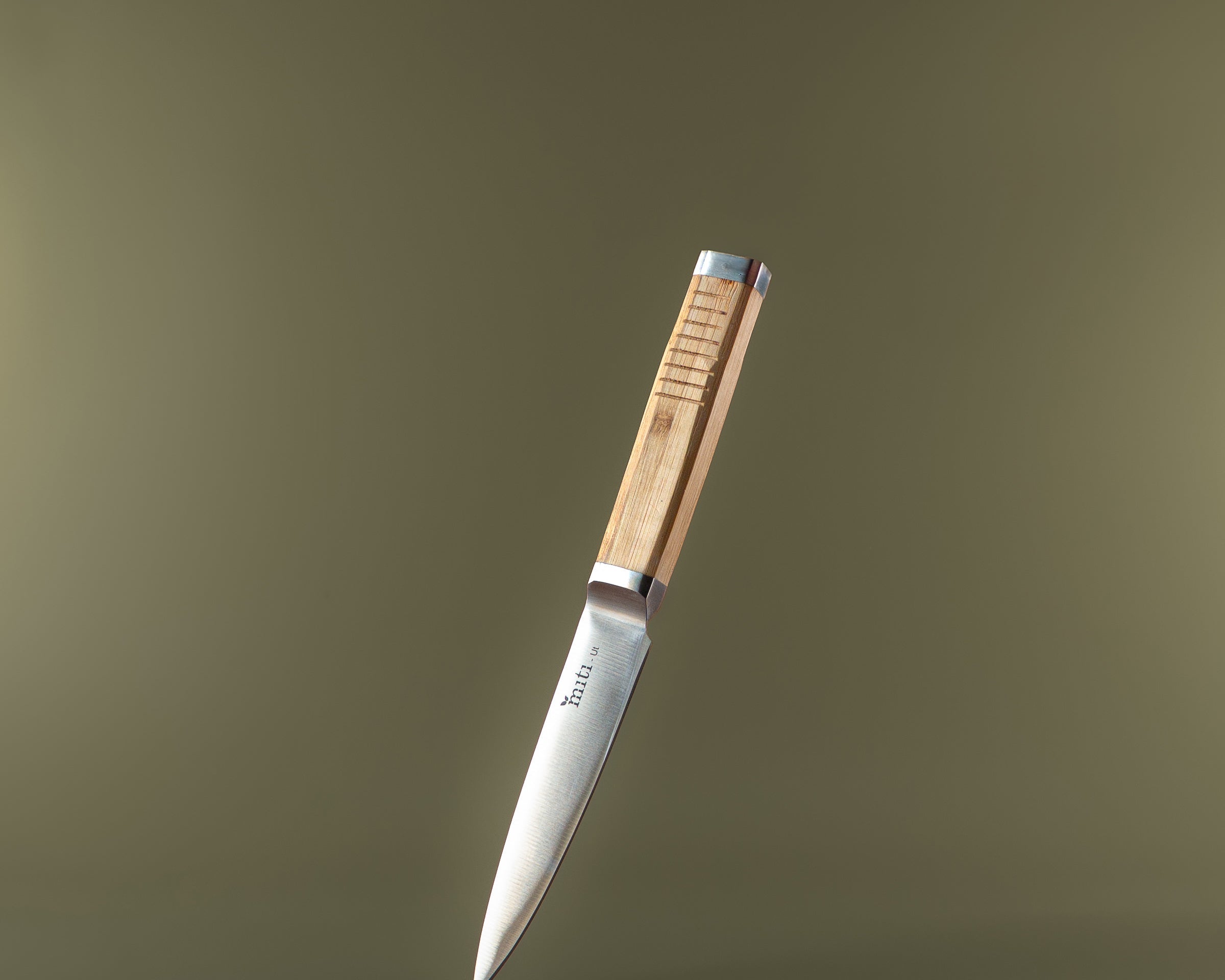 MITI bamboo-handle kitchen knife on an olive background