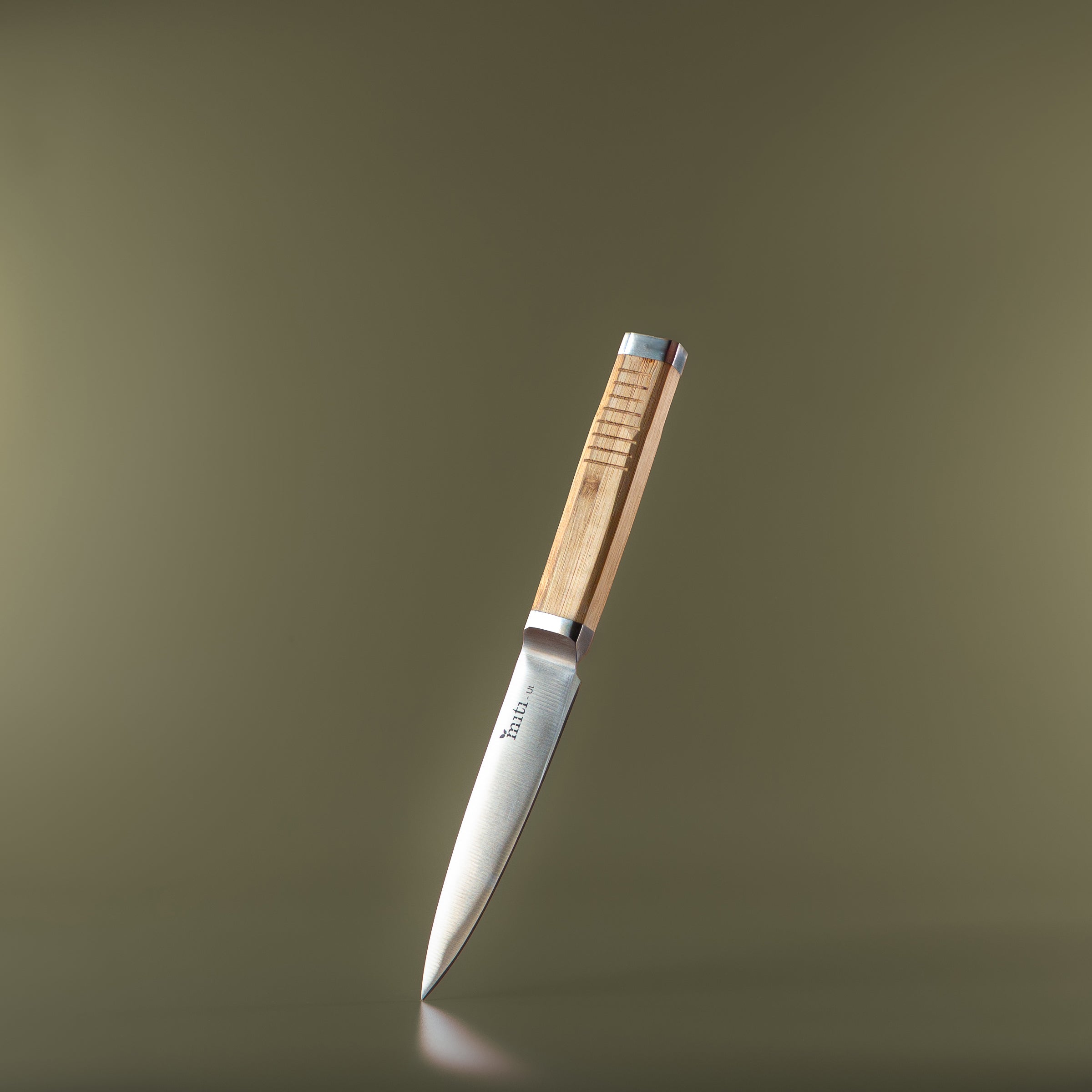 MITI bamboo-handle kitchen knife on an olive background