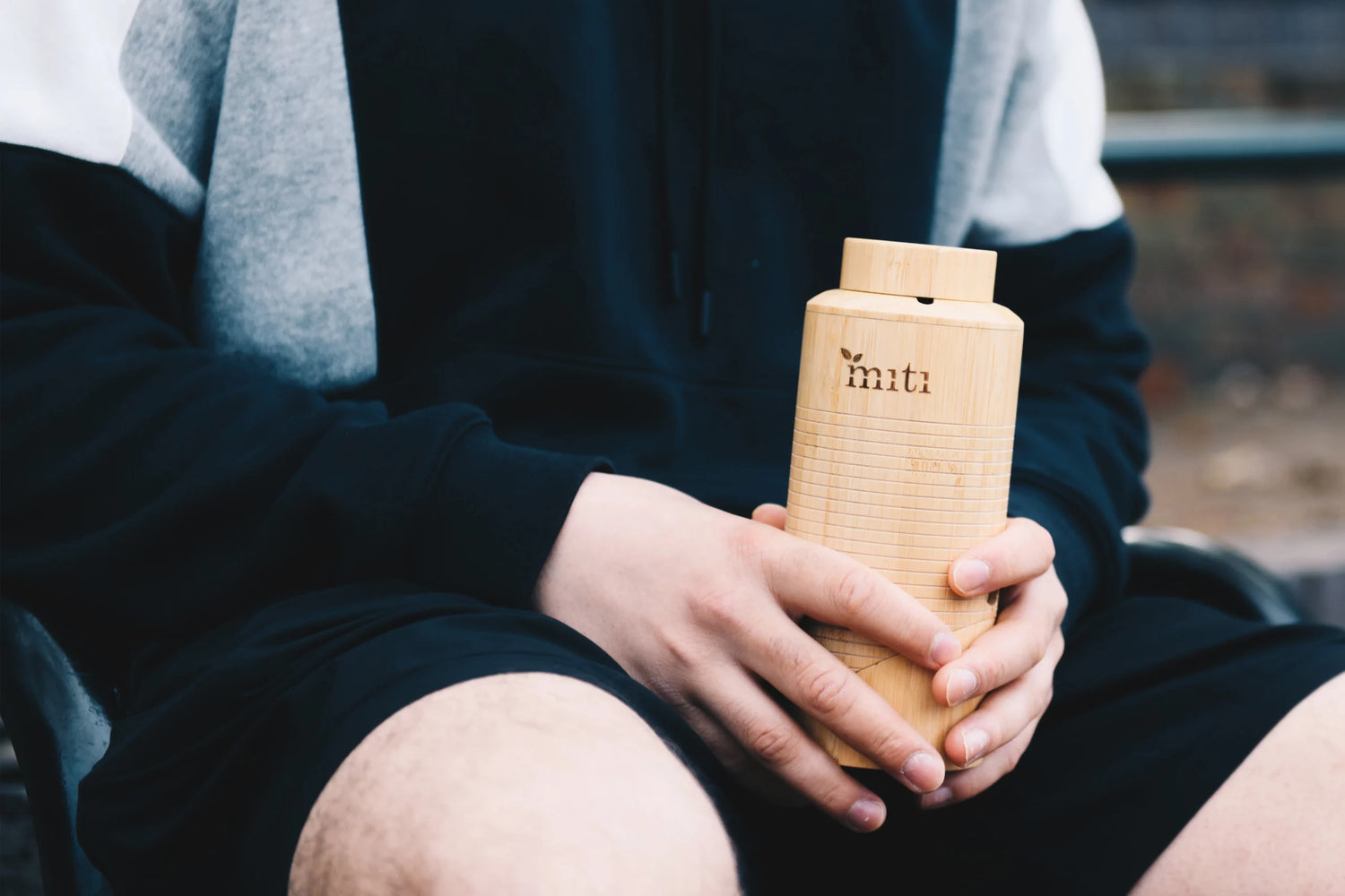 a photo of a man holding one of MITI Life's bamboo water bottle